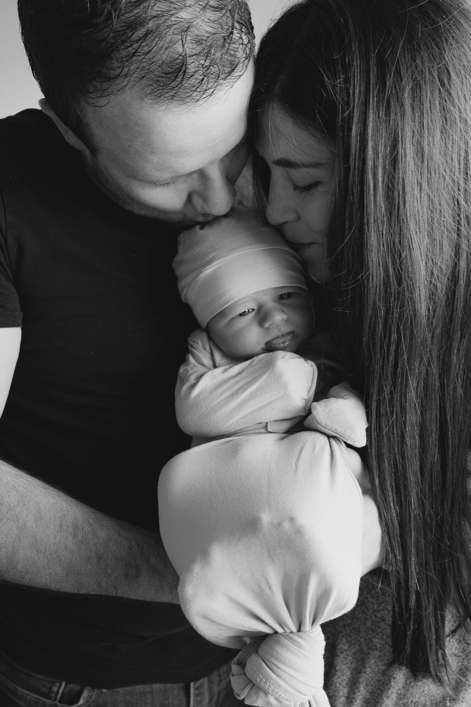Intimate black and white family portrait with newborn baby.