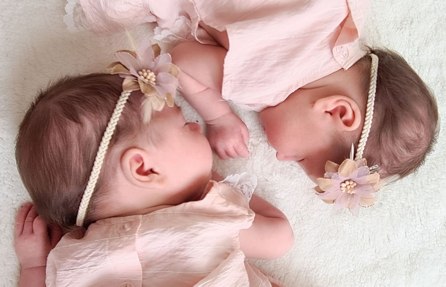 Series of baby portraits in soft pink clothing against white background.