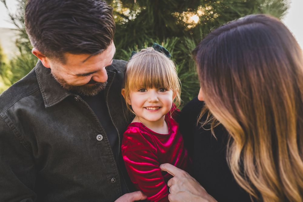 A family shares joyful moments together outdoors during a golden sunset photo session.