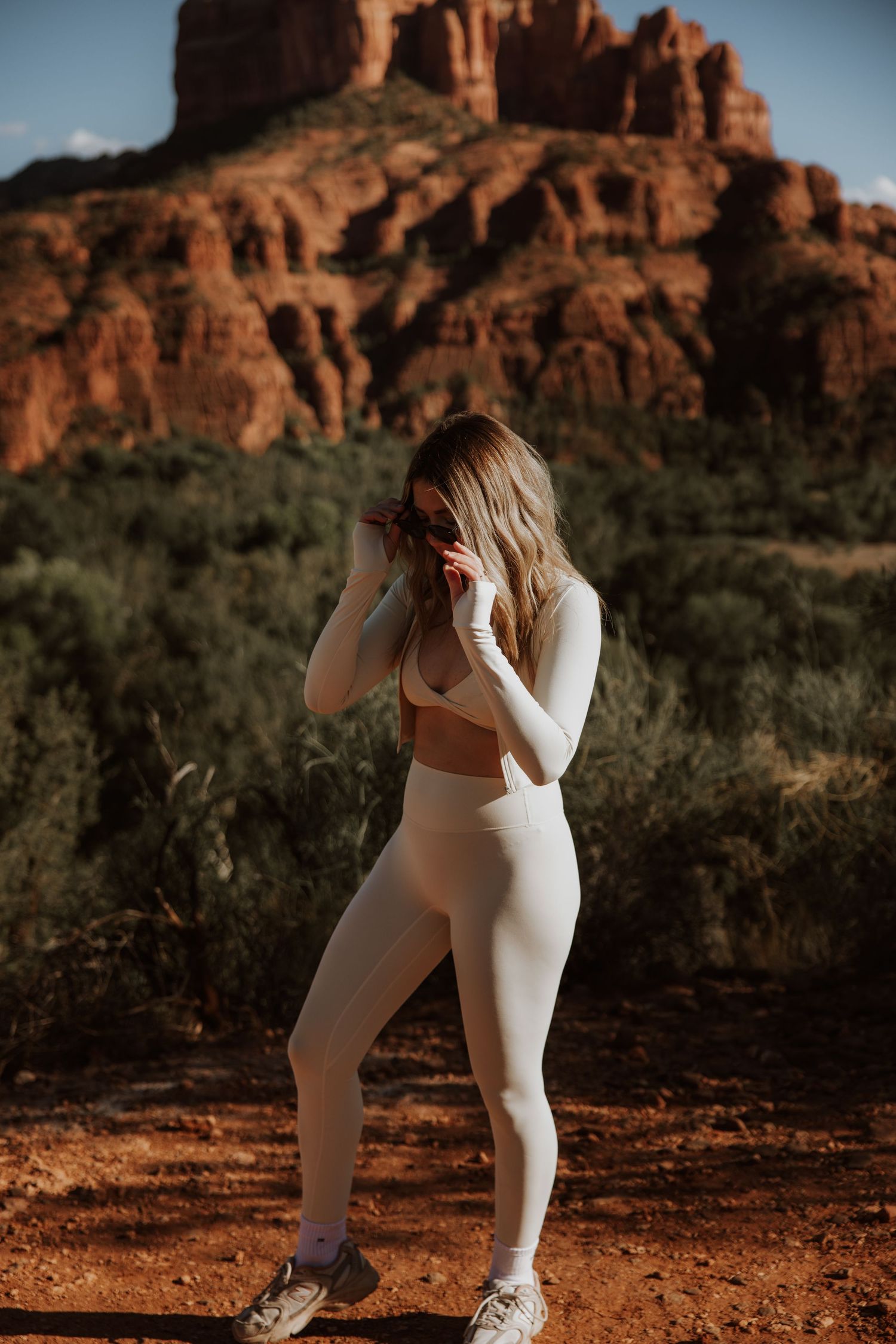 Athletic poses against stunning red rock formations in desert landscape.
