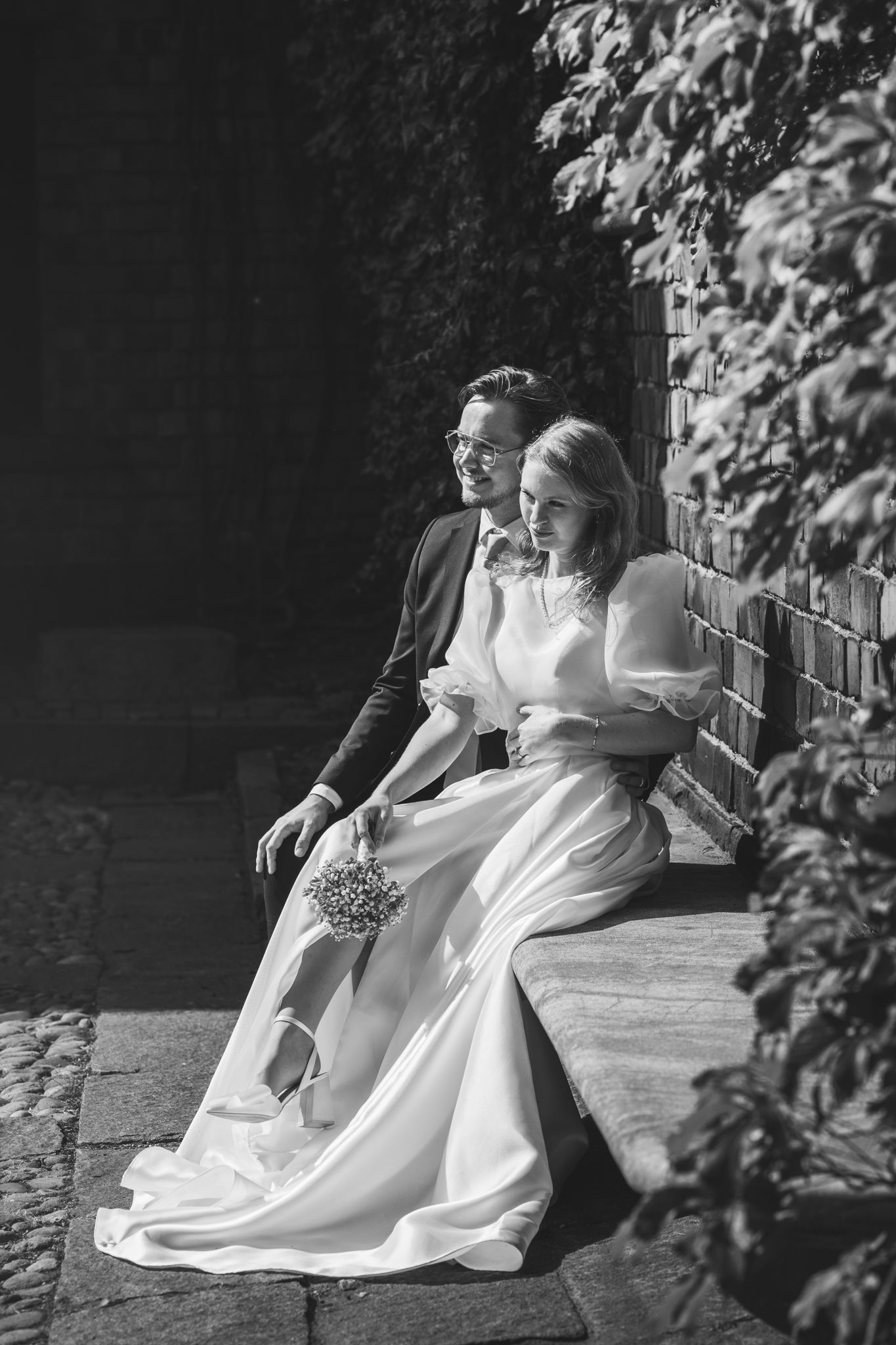 Black and white wedding photo sequence shows couple in elegant attire dancing and dipping on outdoor patio.