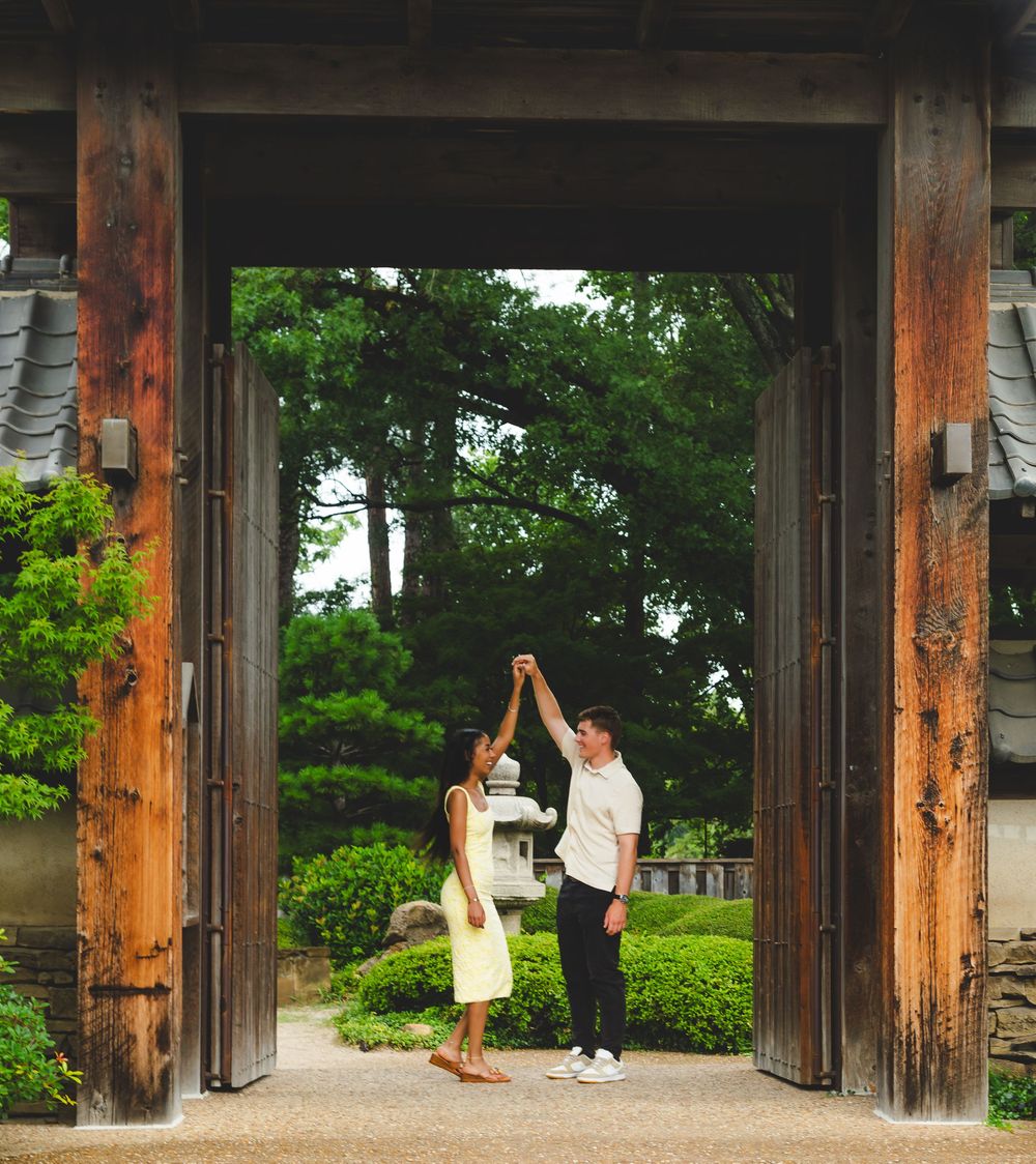 Rustic wooden pavilion in a park with stone columns and natural landscaping.
