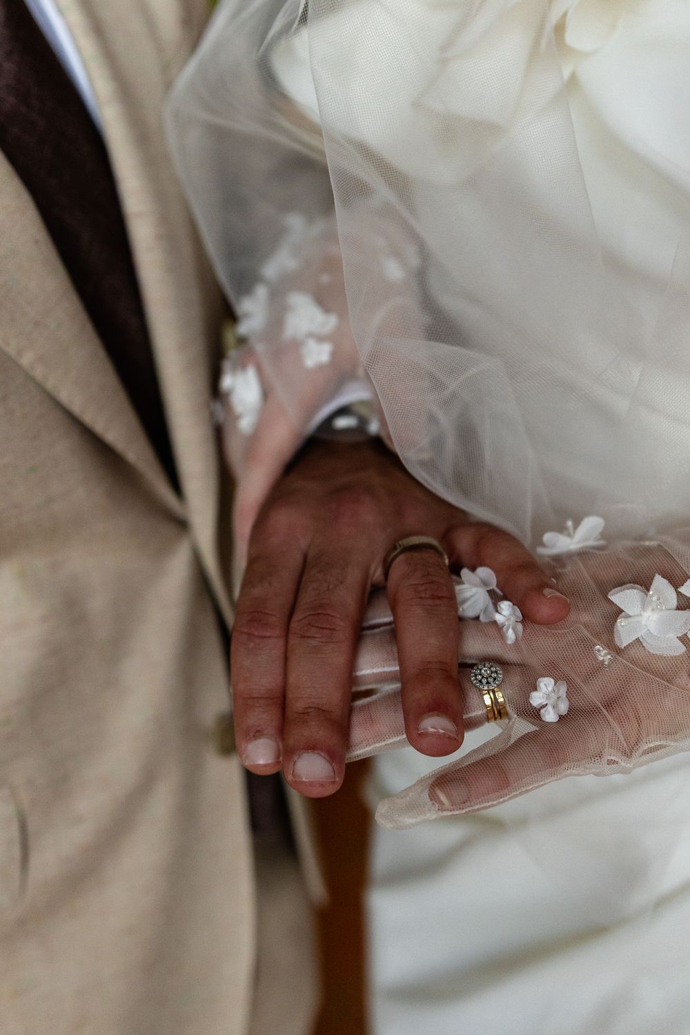 Close-up detail of delicate white floral appliques on sheer wedding veil fabric.