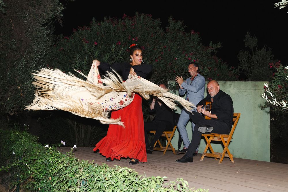 People in medieval costumes perform dramatic scenes at an outdoor nighttime theater event.