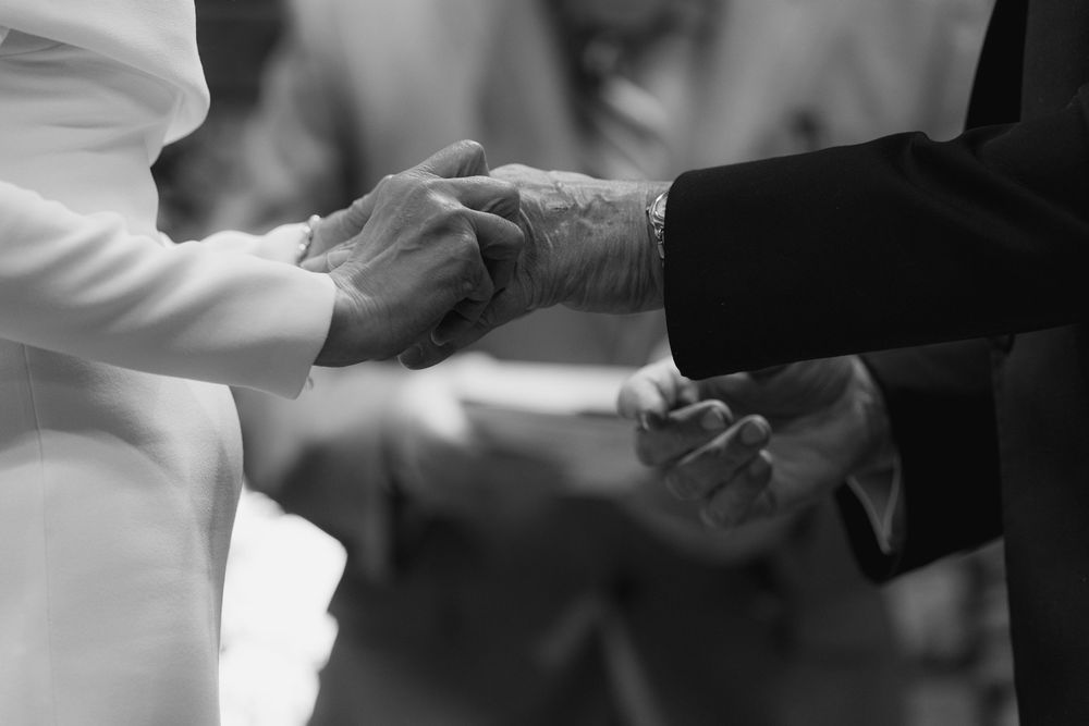 Black and white image showing hands exchanging business cards during a professional meeting.