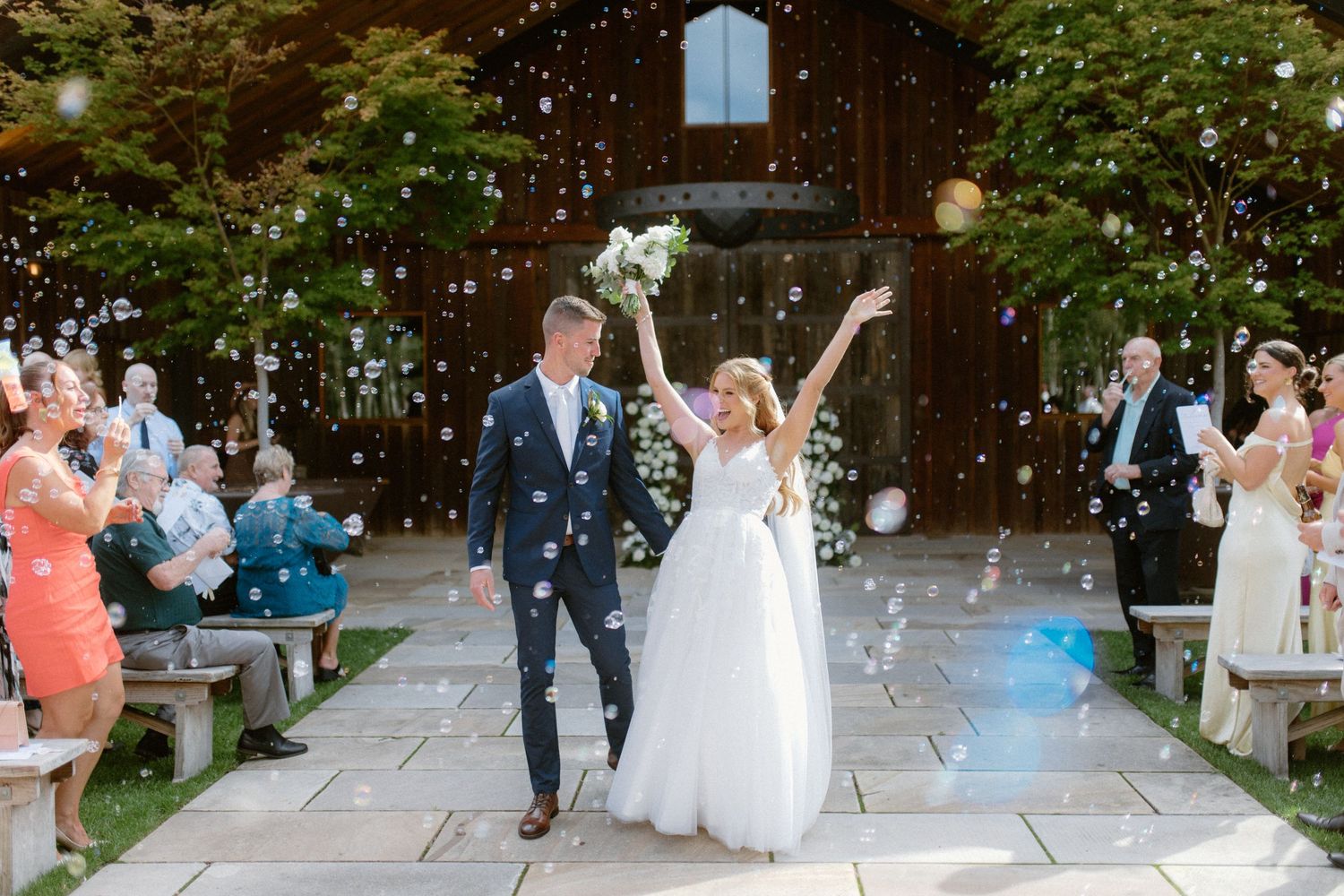 A sequence of wedding celebration photos showing dancing and festivities on an outdoor stone patio surrounded by trees.