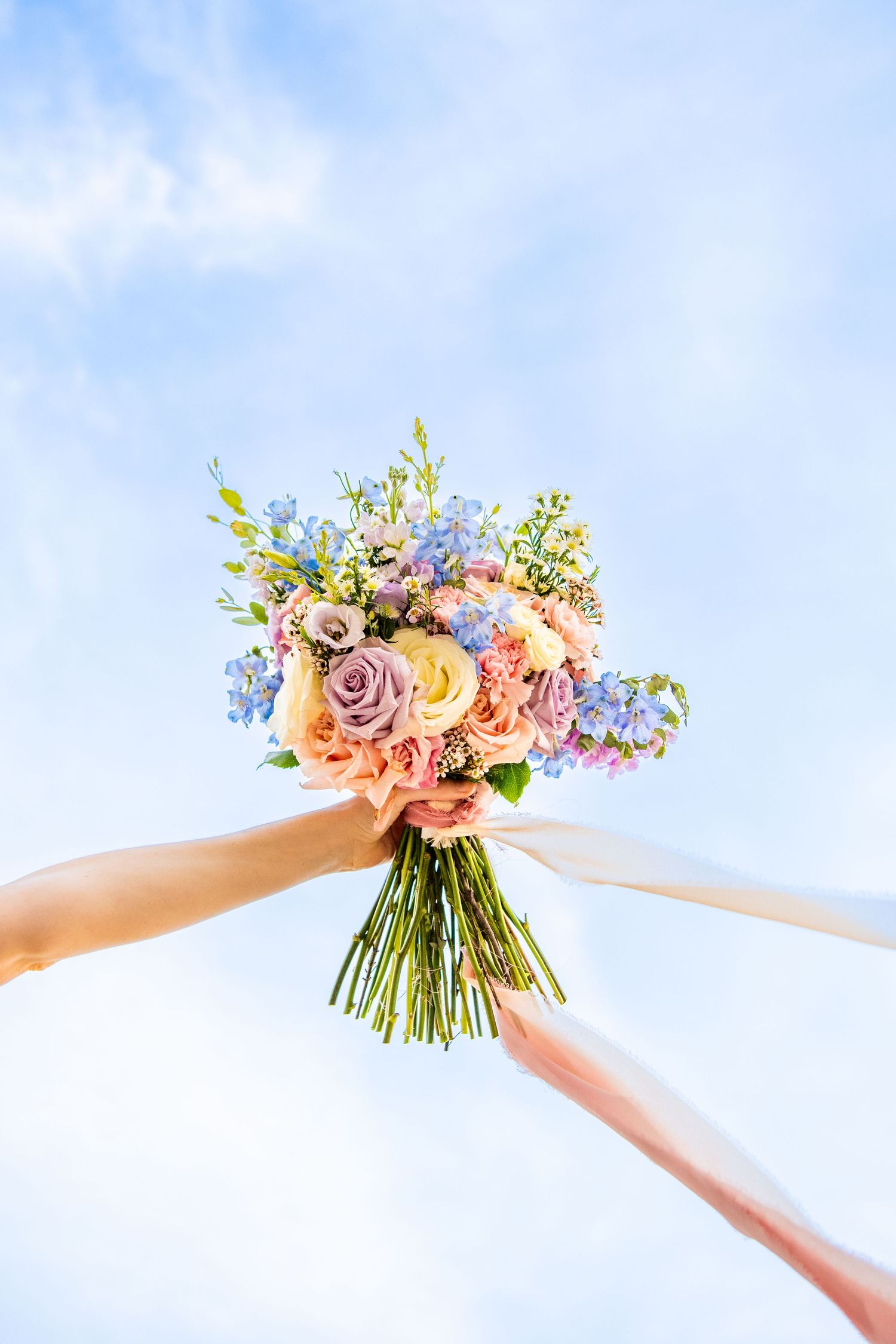 Vibrant floral crown with pink and blue flowers creates a cheerful summer wedding accessory.