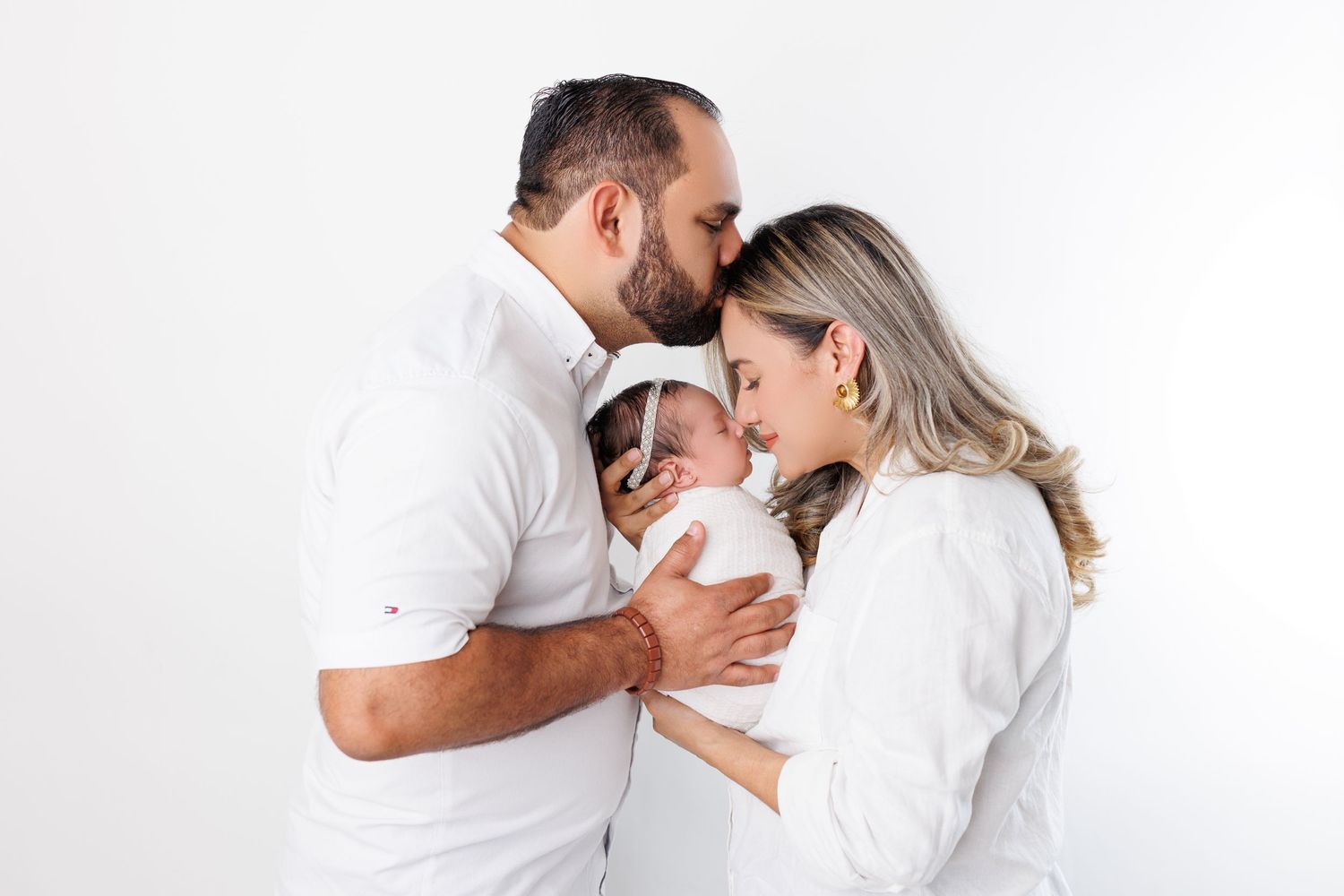 Intimate family portrait in white against clean background.