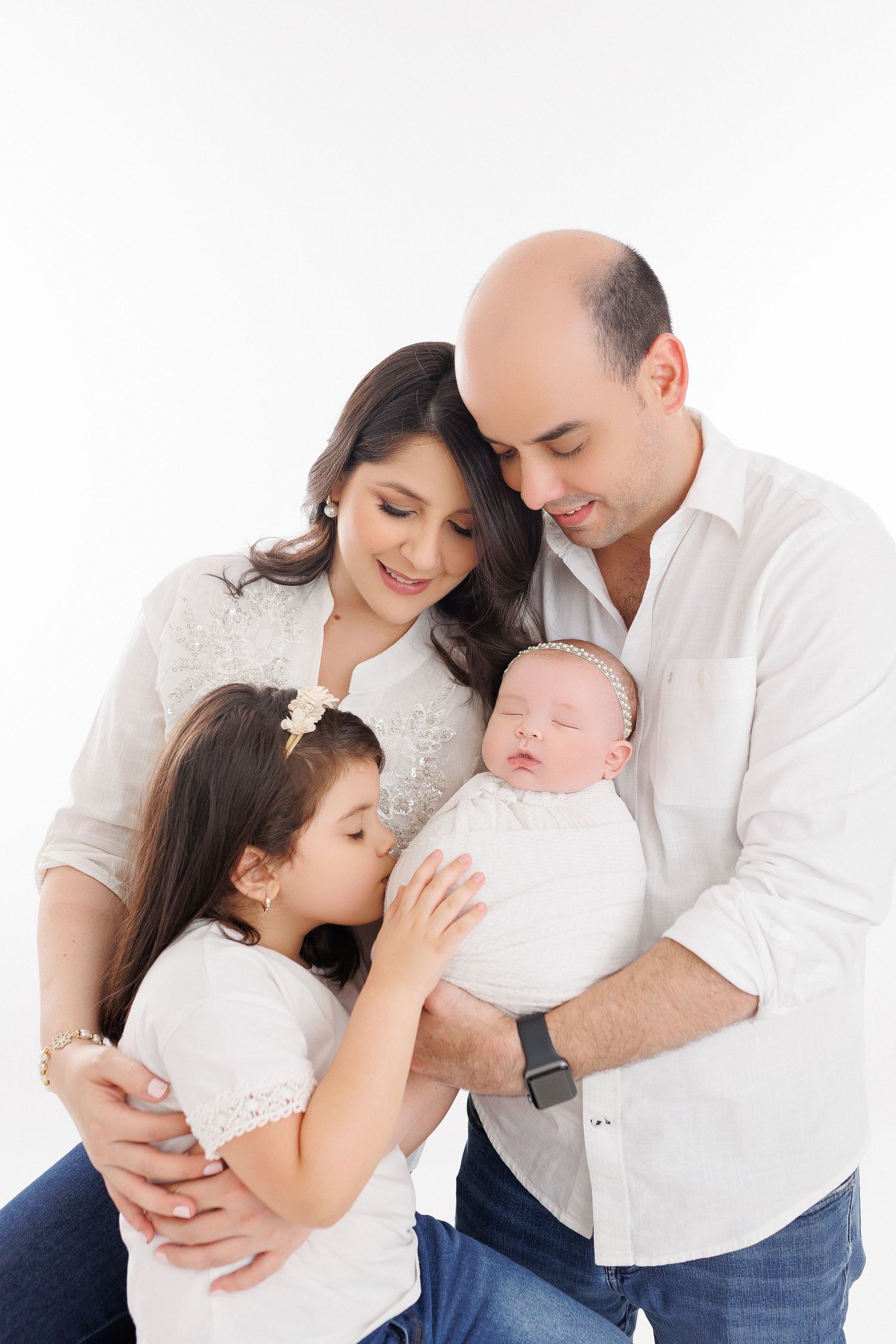A family in white and denim outfits share tender moments with their baby in a series of connected photos.