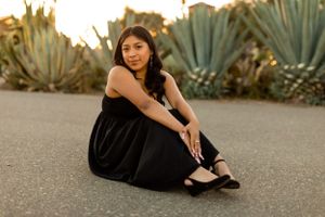 A casual portrait session near agave plants at sunset features a black dress outfit.