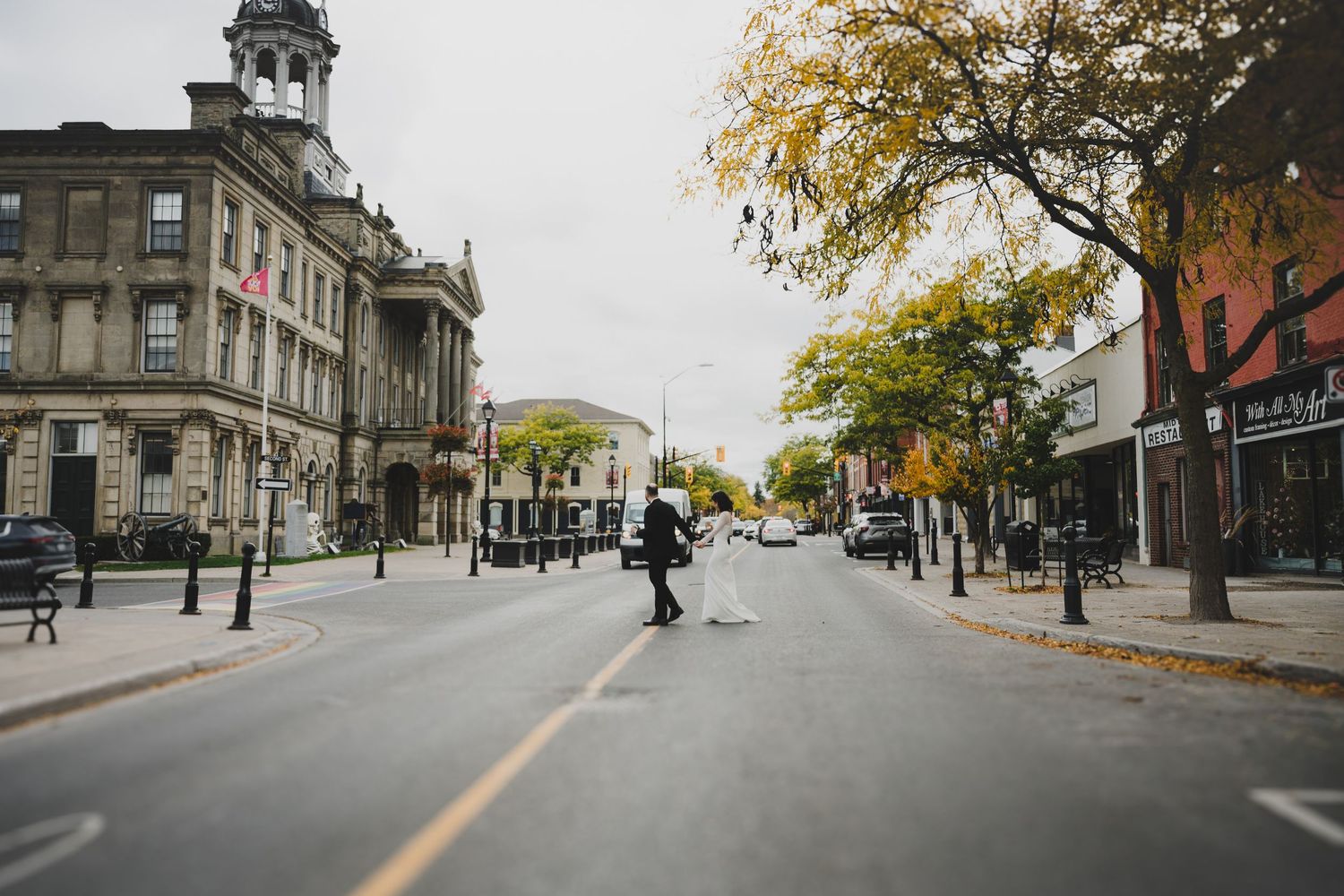 A couple sits at a modern cafe with black walls and yellow foliage, sharing a conversation near a 'Black Cat' sign.