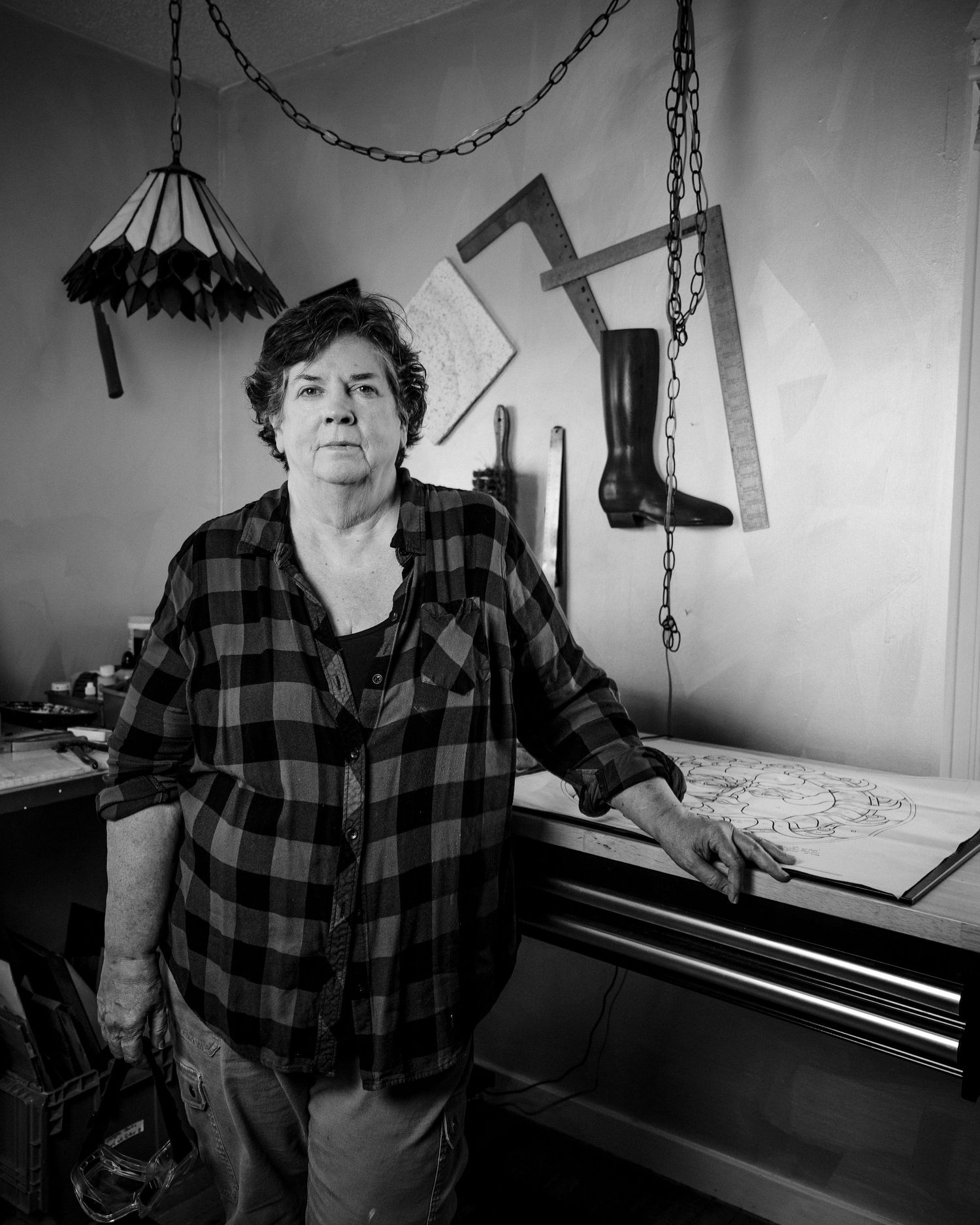 A series of black and white photos showing someone in a plaid shirt at a piano in different contemplative poses.