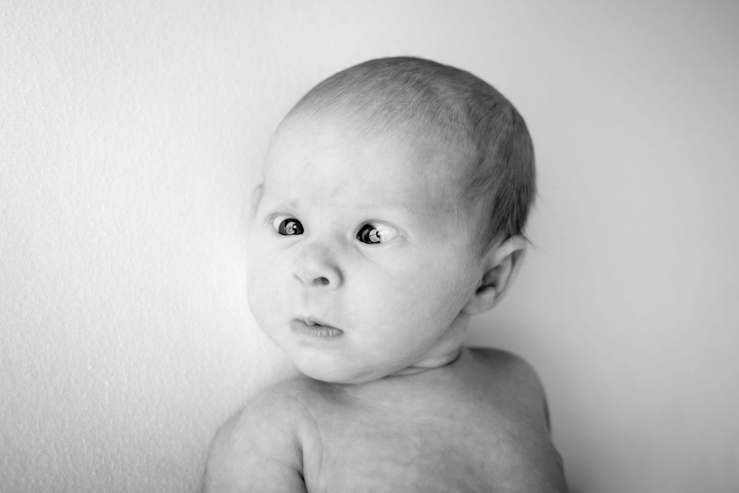 A black and white photo sequence shows a baby's face with changing expressions from left to right.