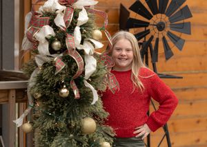Festive holiday decorations including wreaths and ornaments on rustic wood background.