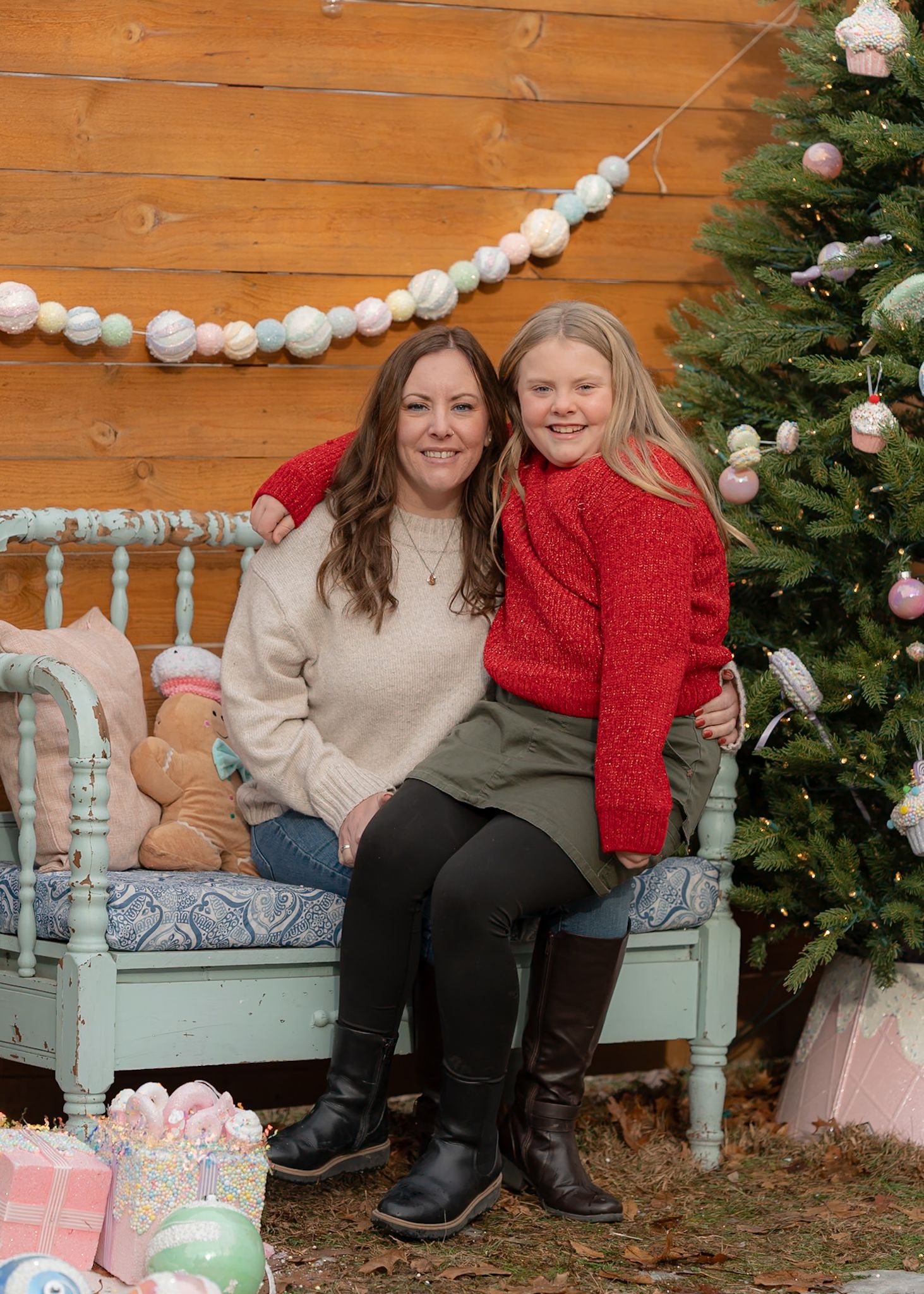 Holiday family photos on a mint-colored bench with Christmas decorations and garland.
