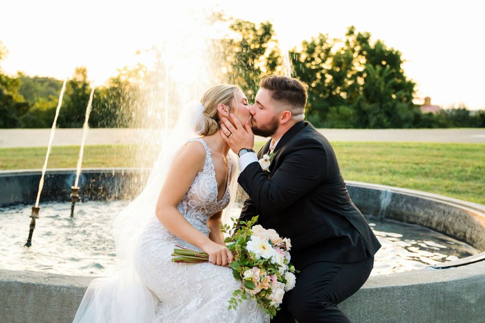 Bride and Groom kissing by the fountain for couple's portraits at The Magnolia Estate Rosewood Manor: Cincinnati wedding photographer