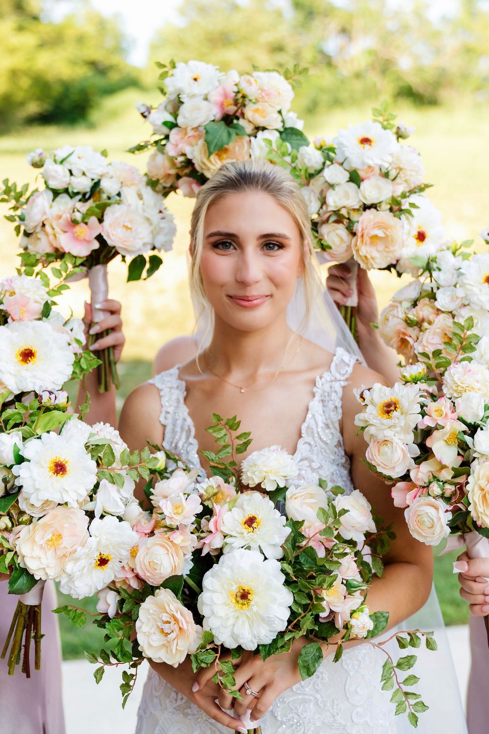 Bride getting bridal portraits with bridesmaids bouquets around her at The Magnolia Estate Rosewood Manor: Cincinnati wedding photographer
