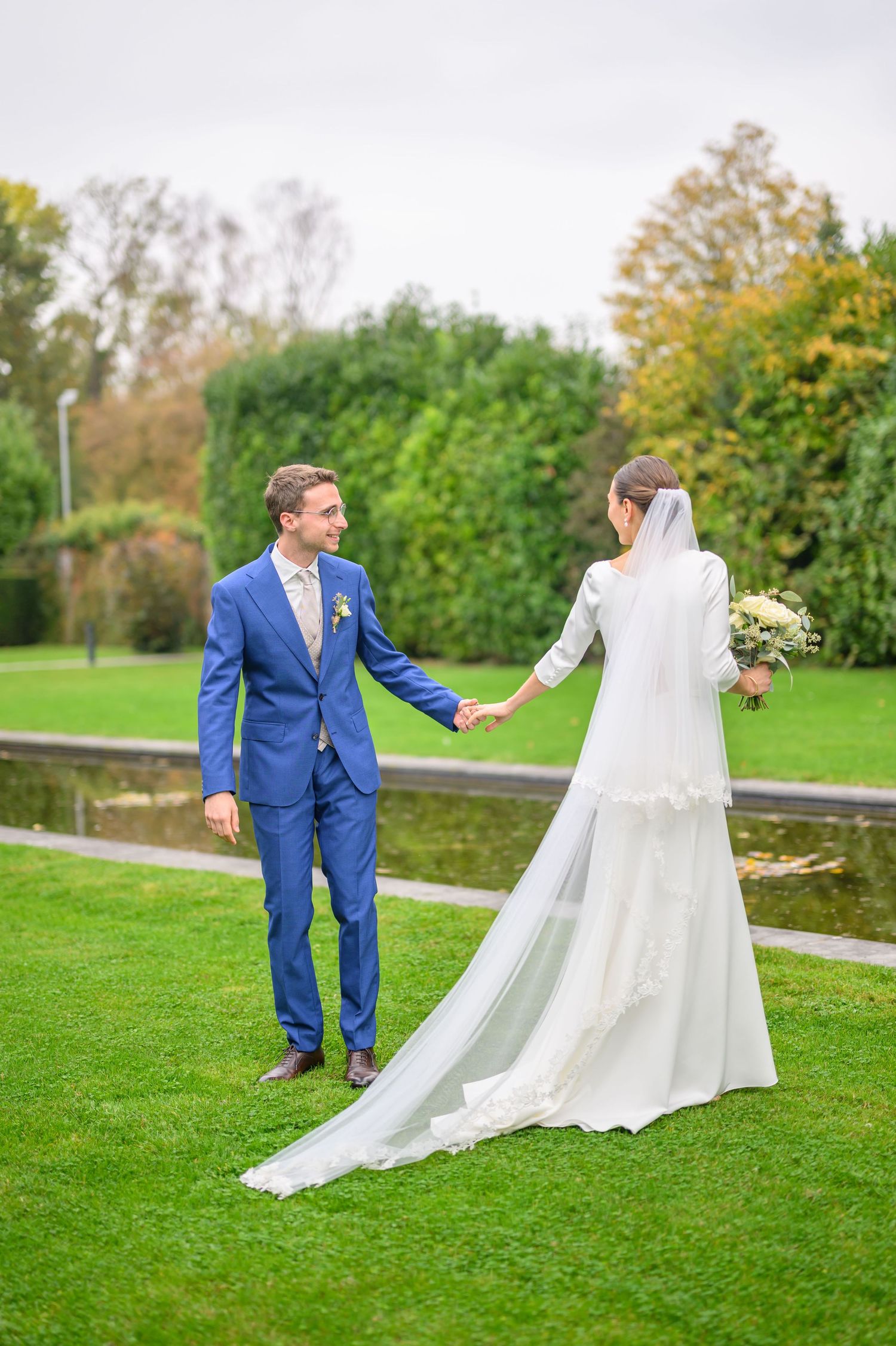 A romantic wedding couple poses in a series of elegant shots under stone archways at a historic European castle.