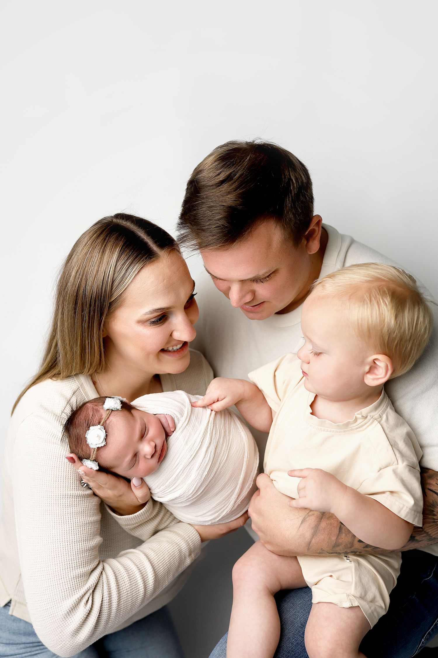 A tender series of candid family moments showing parent and child snuggling and laughing together against a white backdrop.