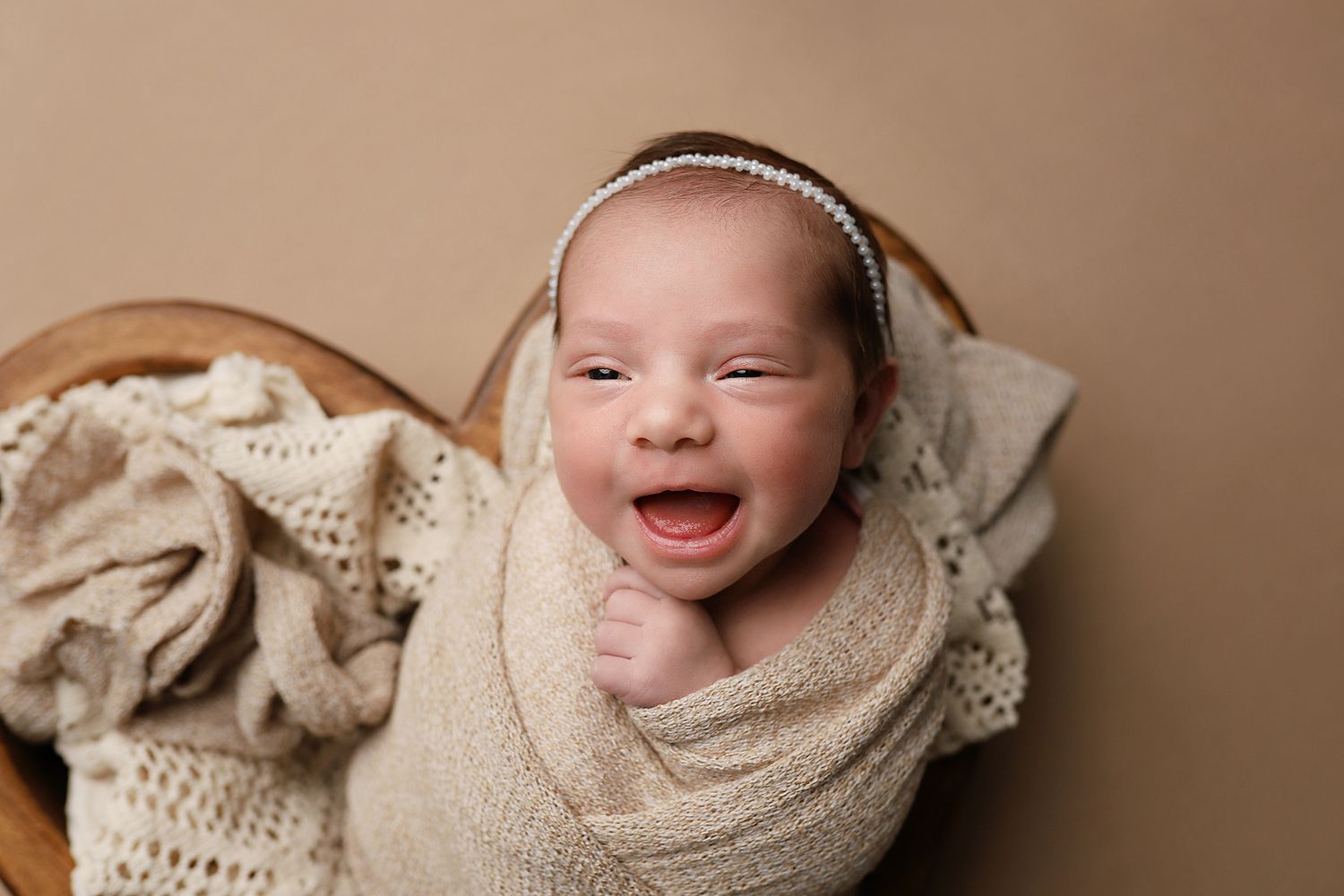 A collection of soft, neutral-toned newborn photography portraits featuring cozy wraps and delicate lace textures.