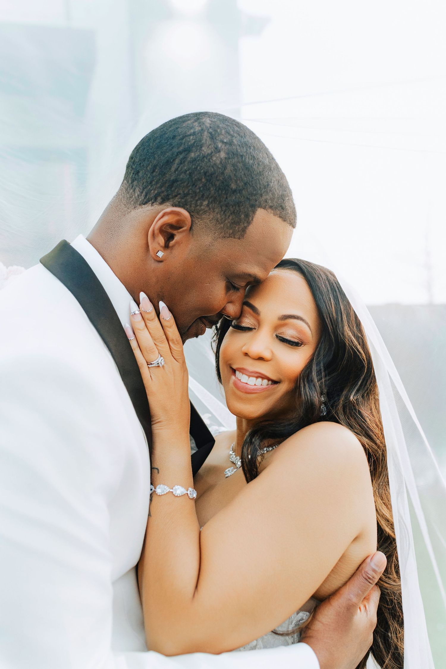 Intimate wedding portrait under delicate white veil.