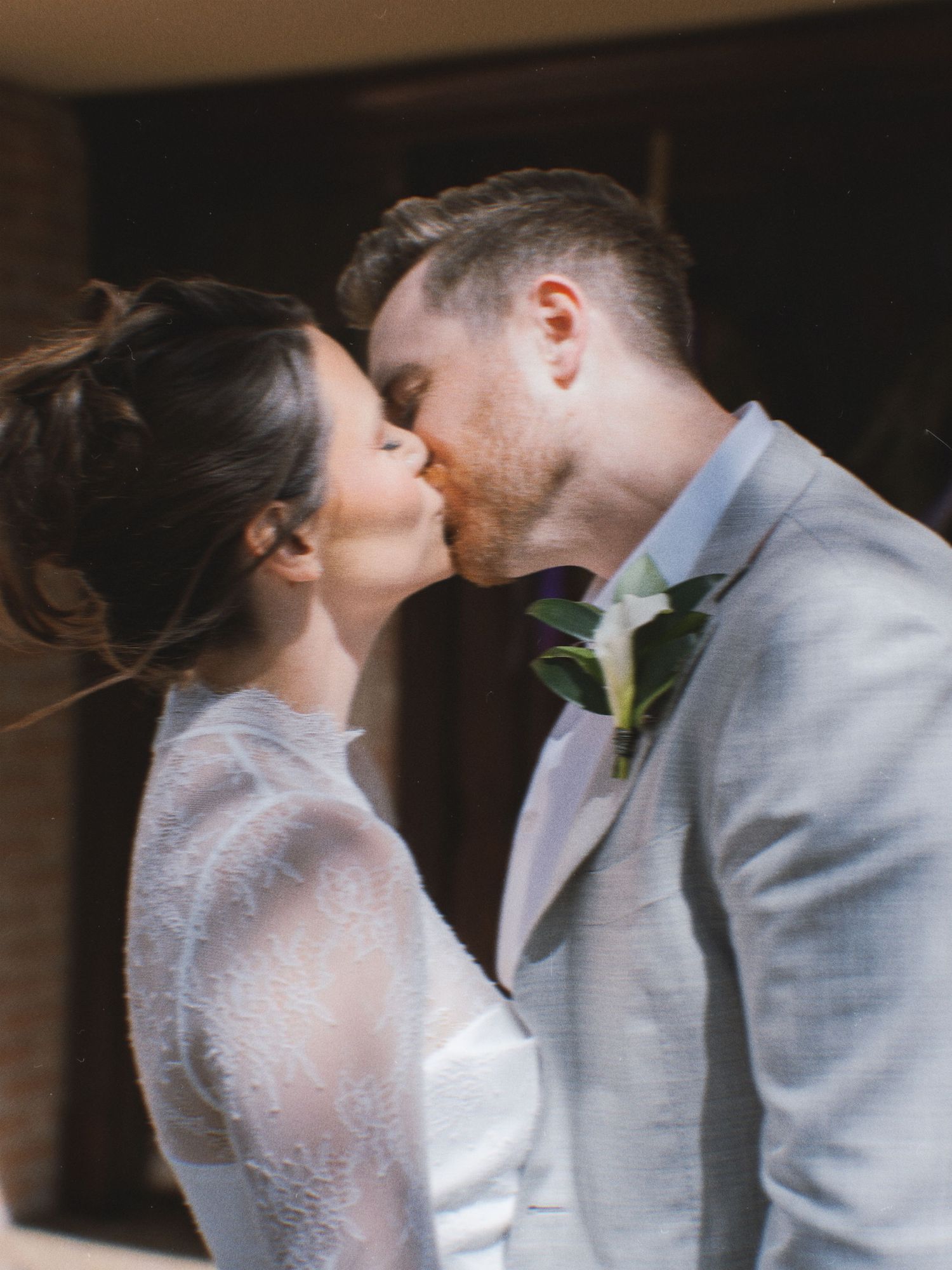 Romantic wedding couple sharing an intimate moment in soft lighting.