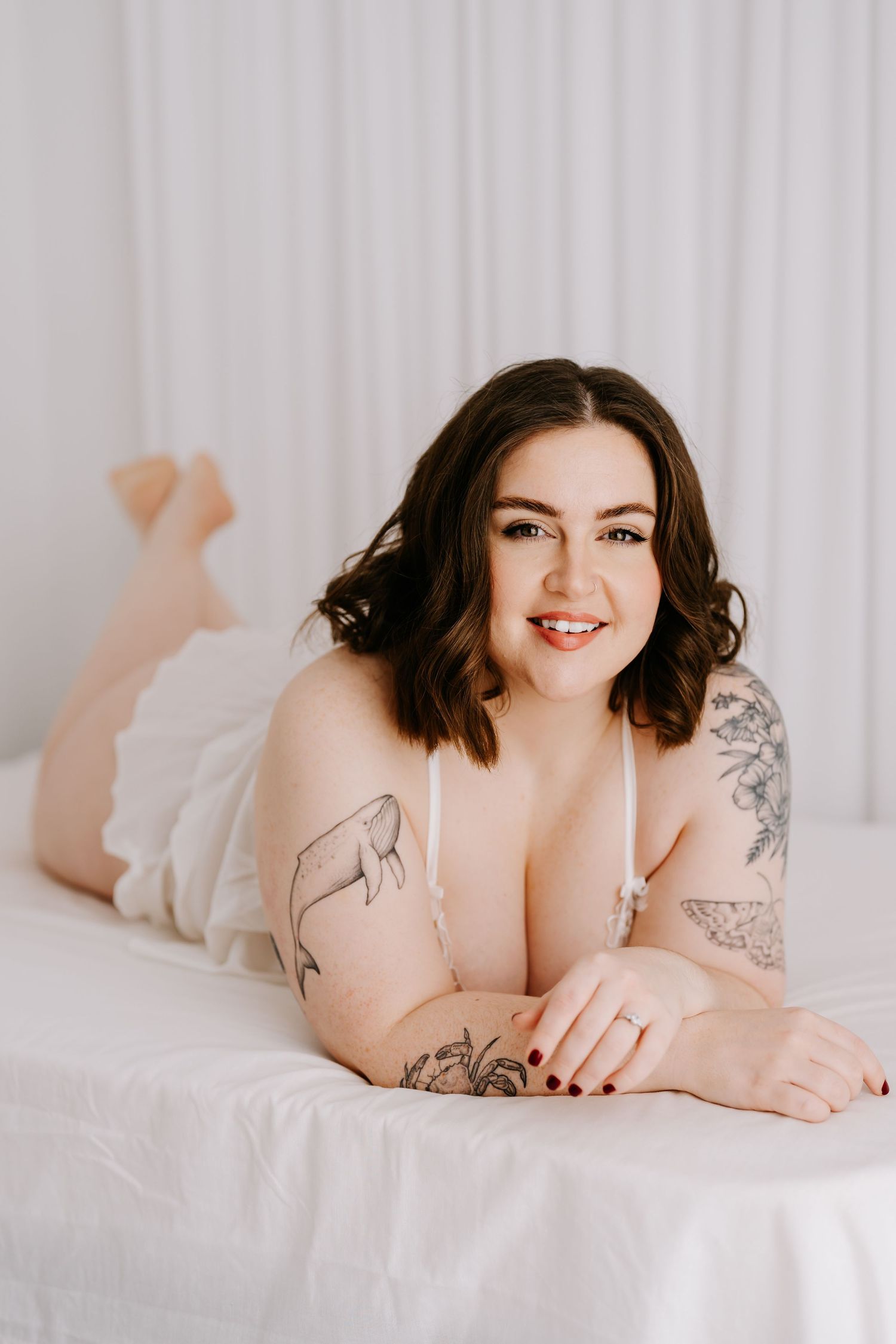 Intimate boudoir photoshoot featuring emerald green silk fabric and black lace lingerie in moody lighting.