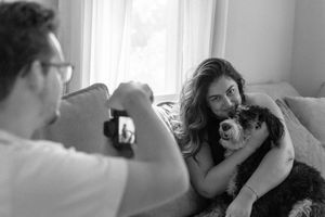 A casual photo session shows tender moments between a couple and their dog at home.