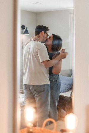 Romantic couple standing close together in a softly lit interior space.