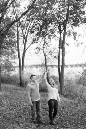 Black and white photo series of a couple playfully dancing together in a wooded outdoor setting.