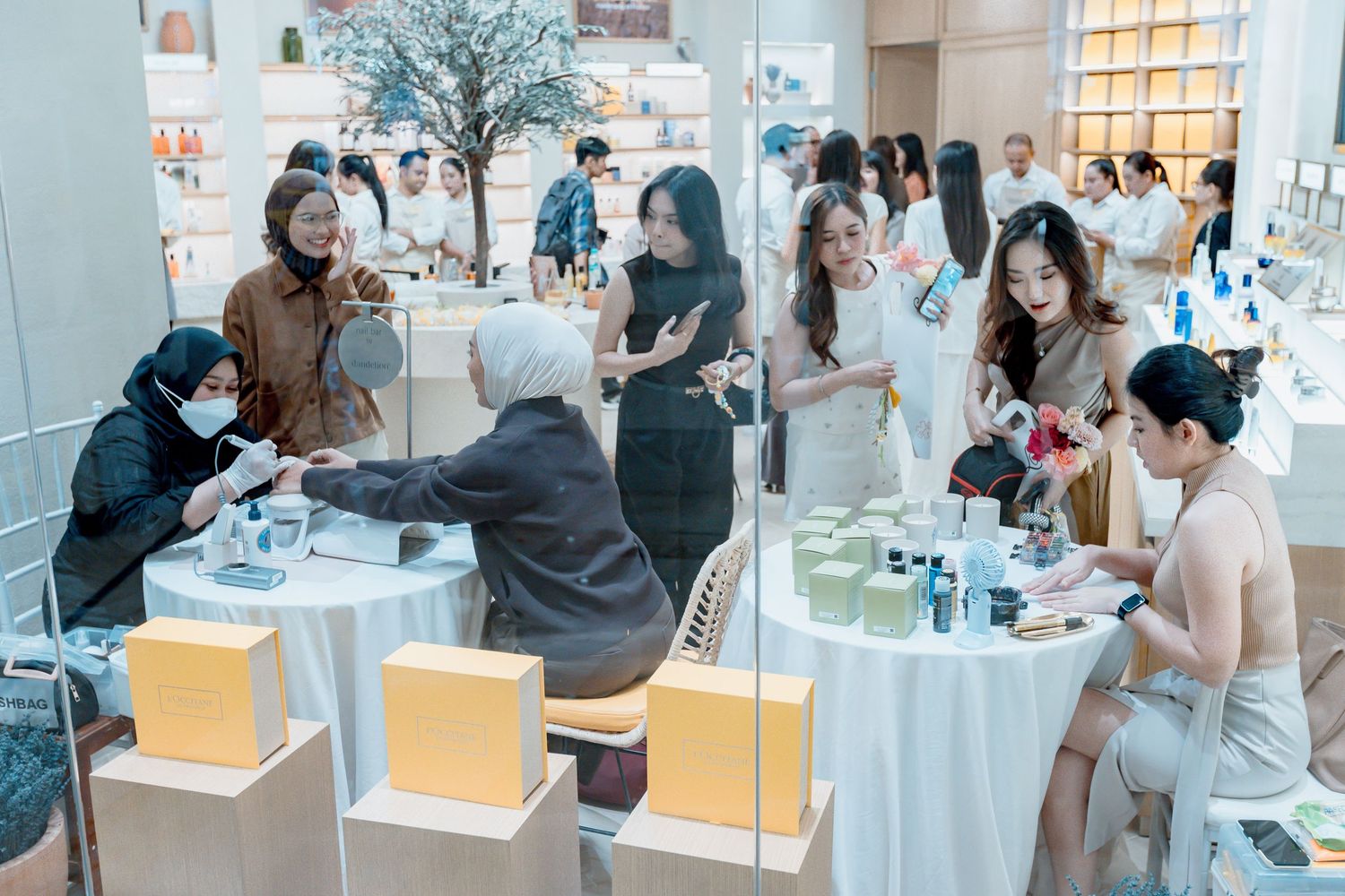 Customers browsing skincare and beauty products at an elegant retail store with white decor and display shelves.