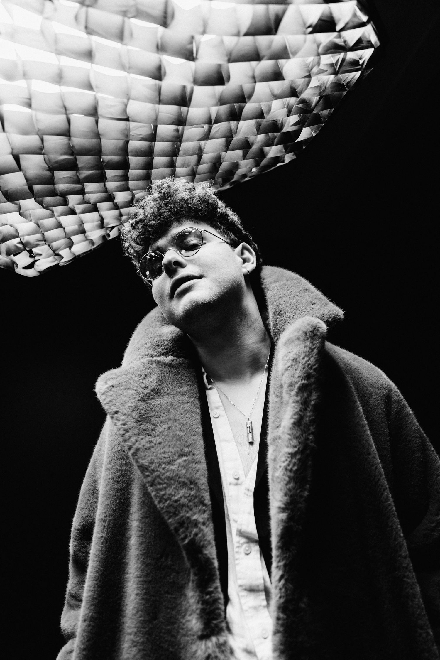 Black and white portrait series showing a figure in a textured coat against a dark background.