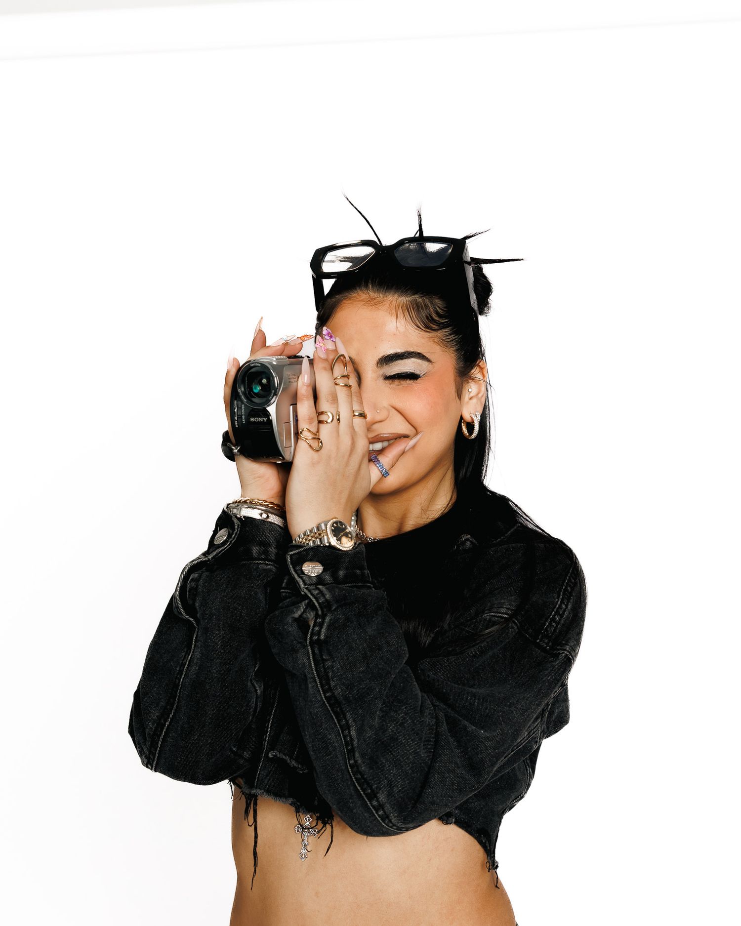 Stylish figure in all black attire with sunglasses poses in multiple angles showing off fashion ensemble.