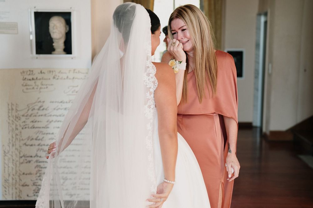 A bride hugs an emotional guest during wedding preparations in Sanremo.
