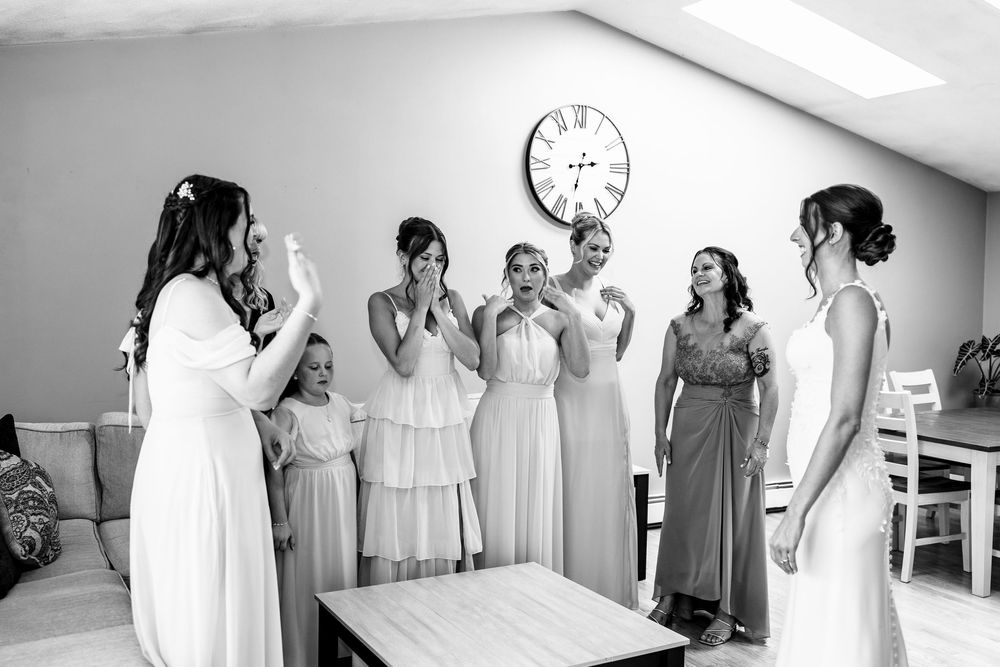 A series of black and white wedding preparation photos showing bridesmaids in white dresses getting ready for the ceremony.
