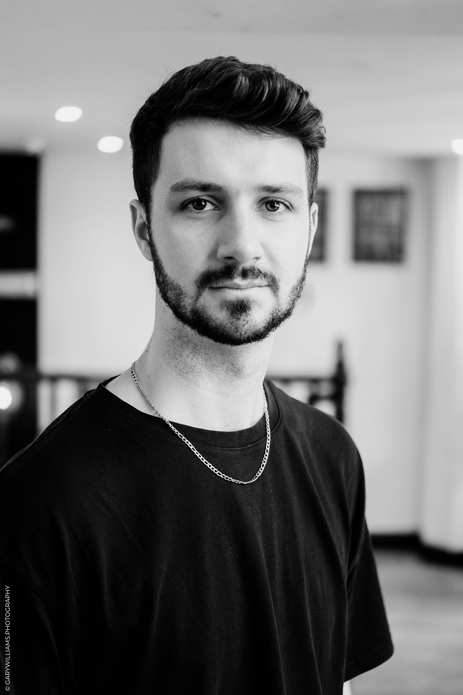 A black and white photo series showing a person wearing a dark sweater and cap in different poses and angles.