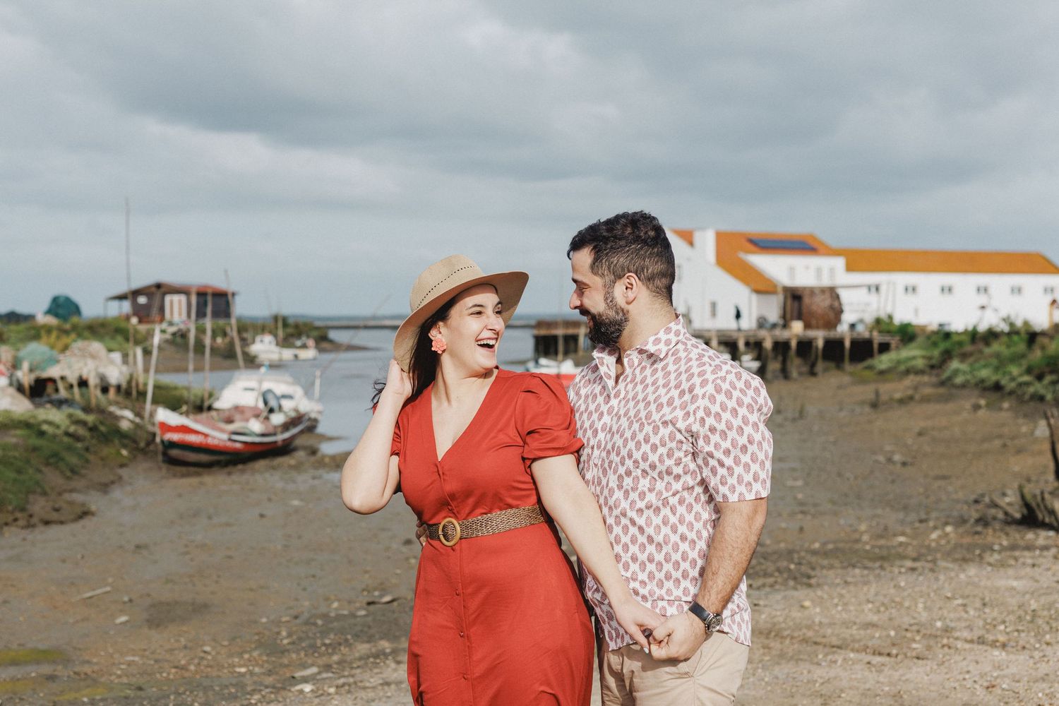Romantic couple embracing and looking at traditional houses in Moinho da Mourisca Setúbal pre wedding session
