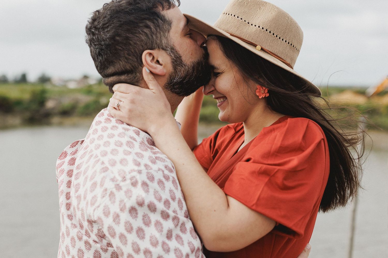 Romantic couple standing on wooden dock near river boats at Moinho da Mourisca pre wedding session Portugal
