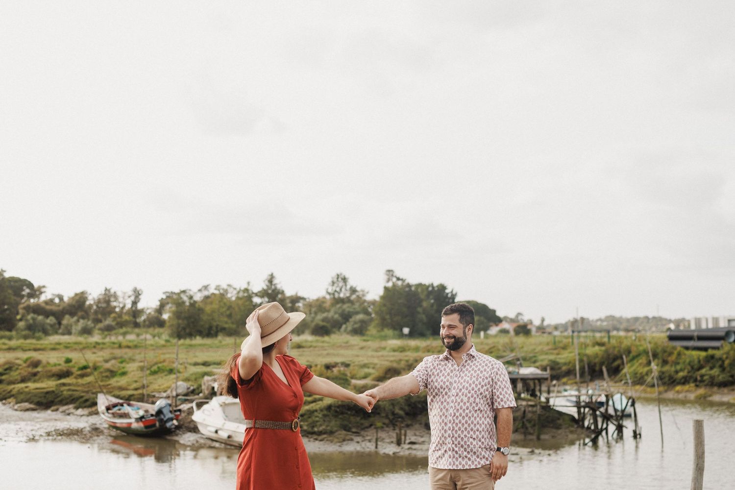Playful couple holding hands by the river during pre wedding photoshoot in Moinho da Mourisca Setúbal