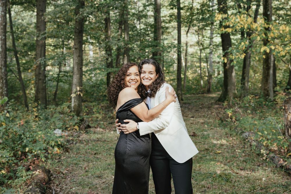 A couple embraces in a romantic woodland setting during a photo session.