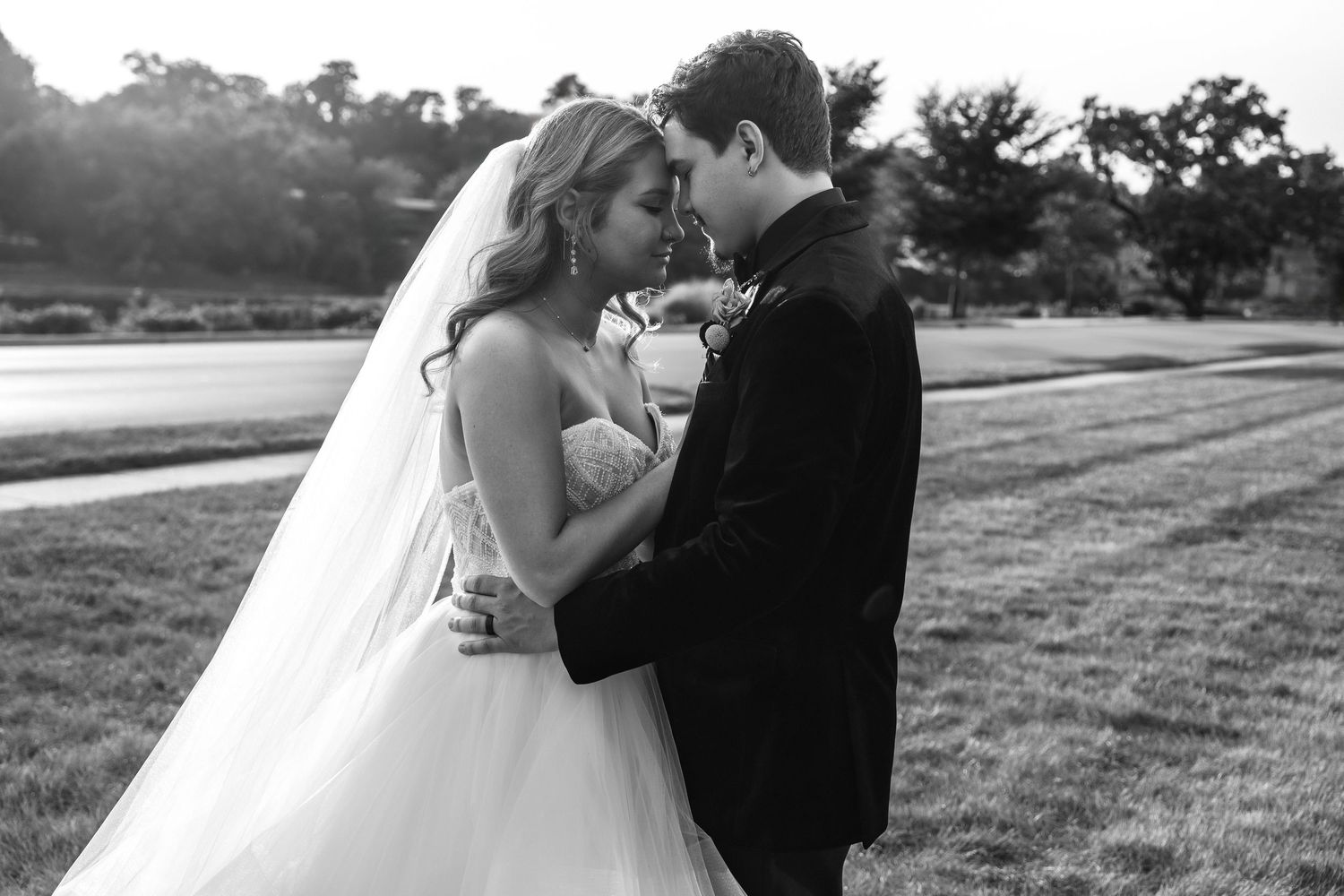 A romantic black and white wedding photo series showing a couple sharing intimate moments in an outdoor setting.