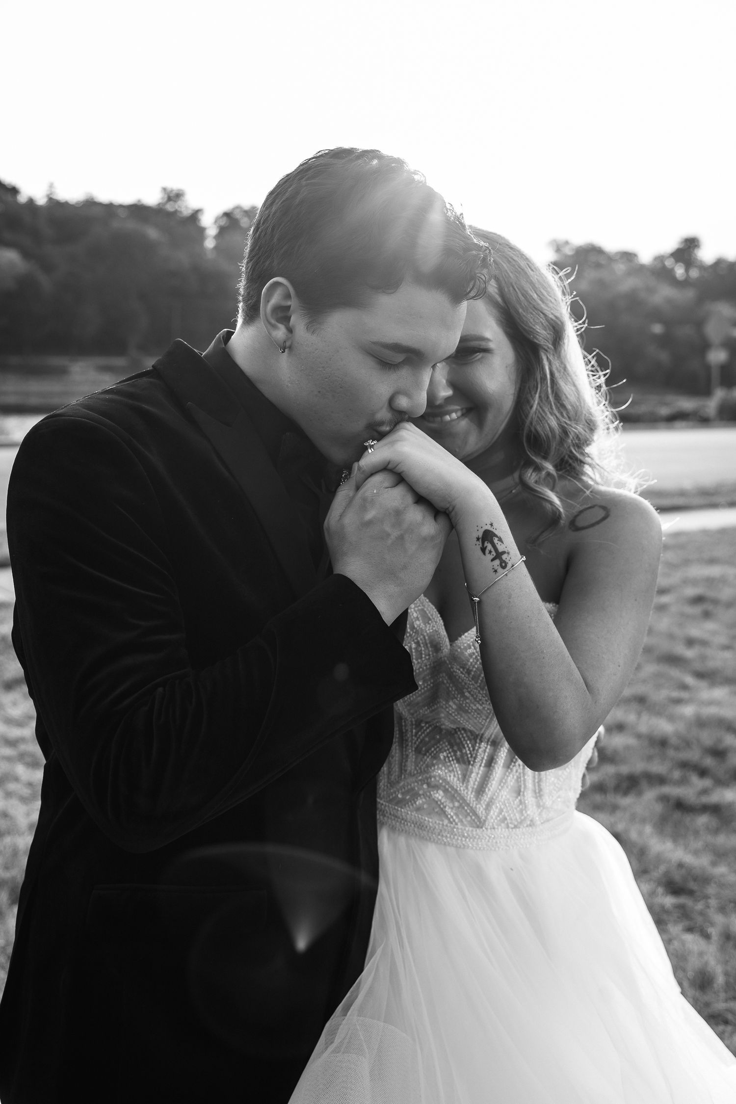 A romantic black and white photo sequence shows a couple sharing tender kisses during their wedding photoshoot outdoors.