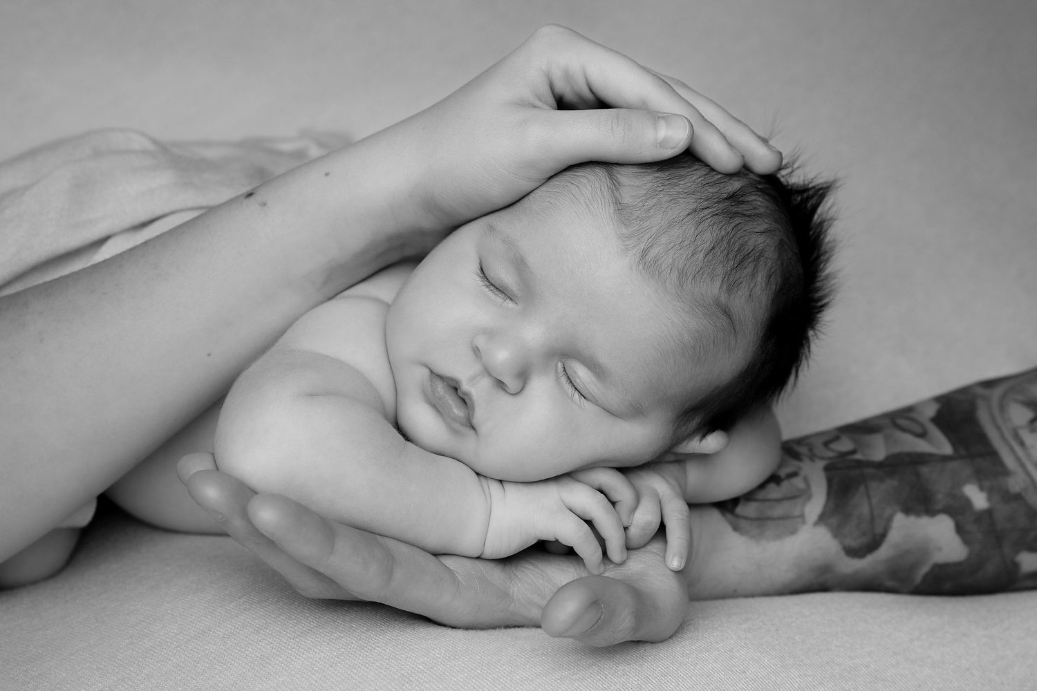Black and white panoramic series of a sleeping newborn baby in peaceful poses against a soft backdrop.