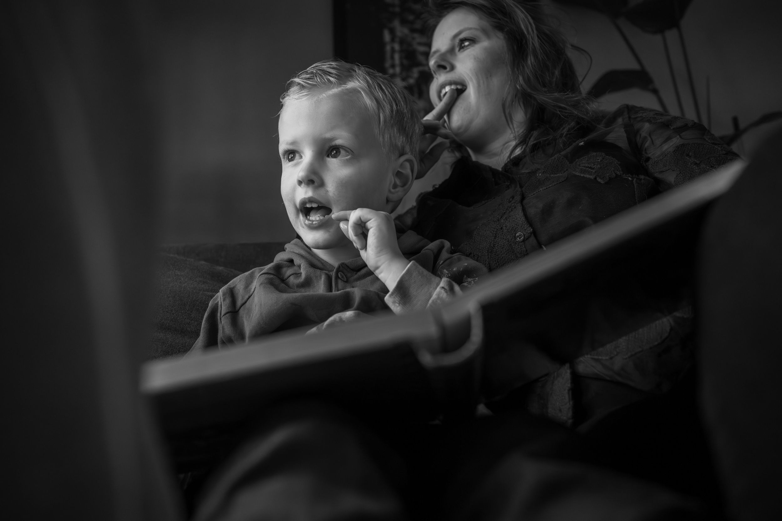 A black and white candid moment of a parent and child enjoying a performance or show together.
