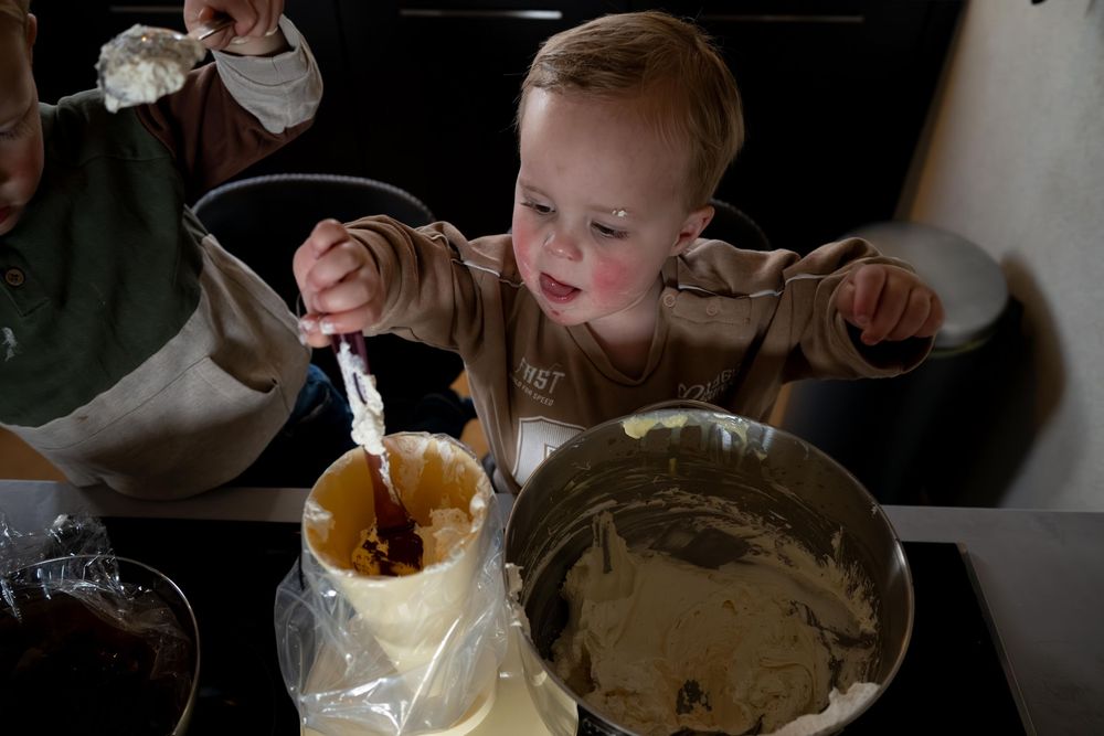 A person mixes ingredients in a large bowl while preparing what appears to be a chocolate dessert recipe.