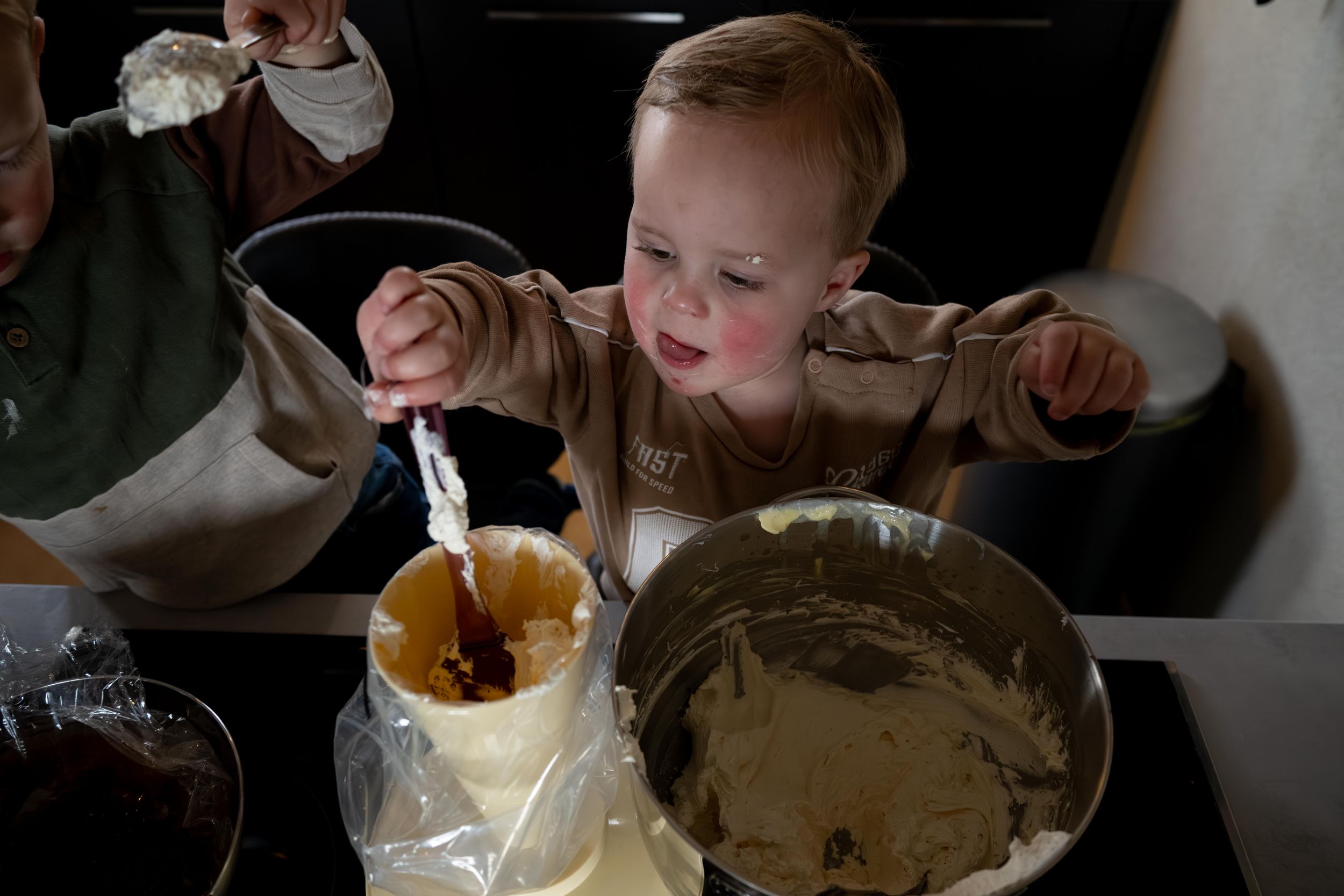 A person mixes ingredients in a large bowl while preparing what appears to be a chocolate dessert recipe.
