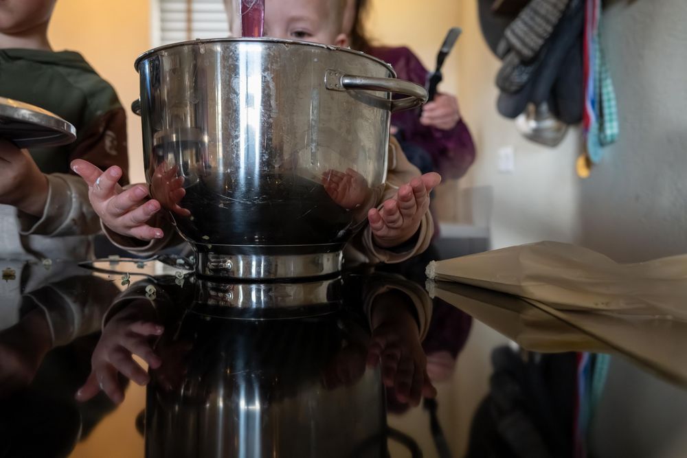 A person pours hot water in a circular motion over coffee grounds in a filter cone during the brewing process.