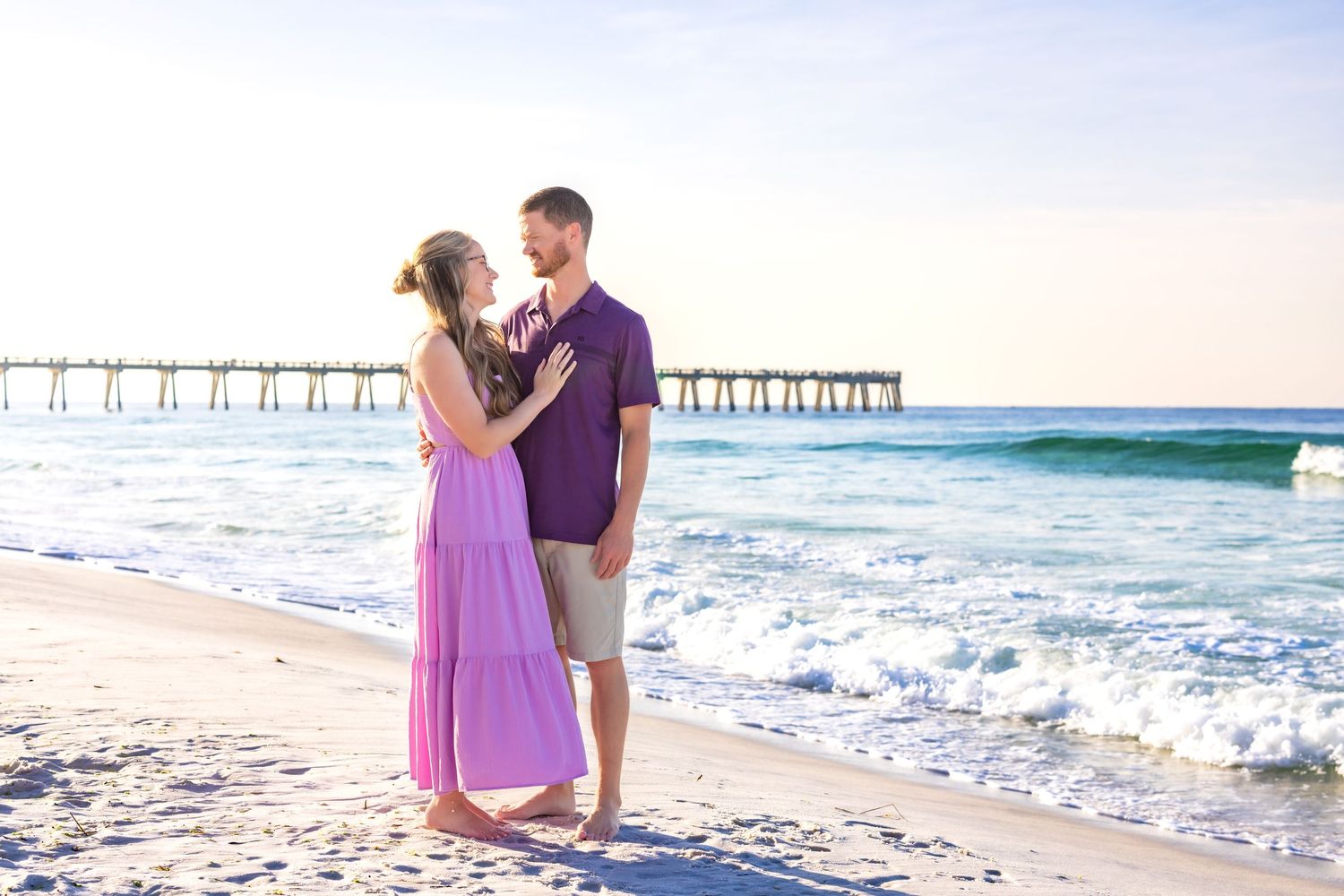 Couple shares romantic moments on a sunny beach with pier and ocean waves in multiple connected photos.