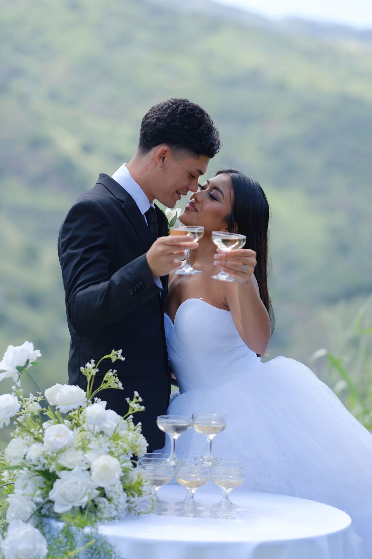 Newlyweds sharing champagne toast during an elopement photography session on North Shore Oahu, Hawaii