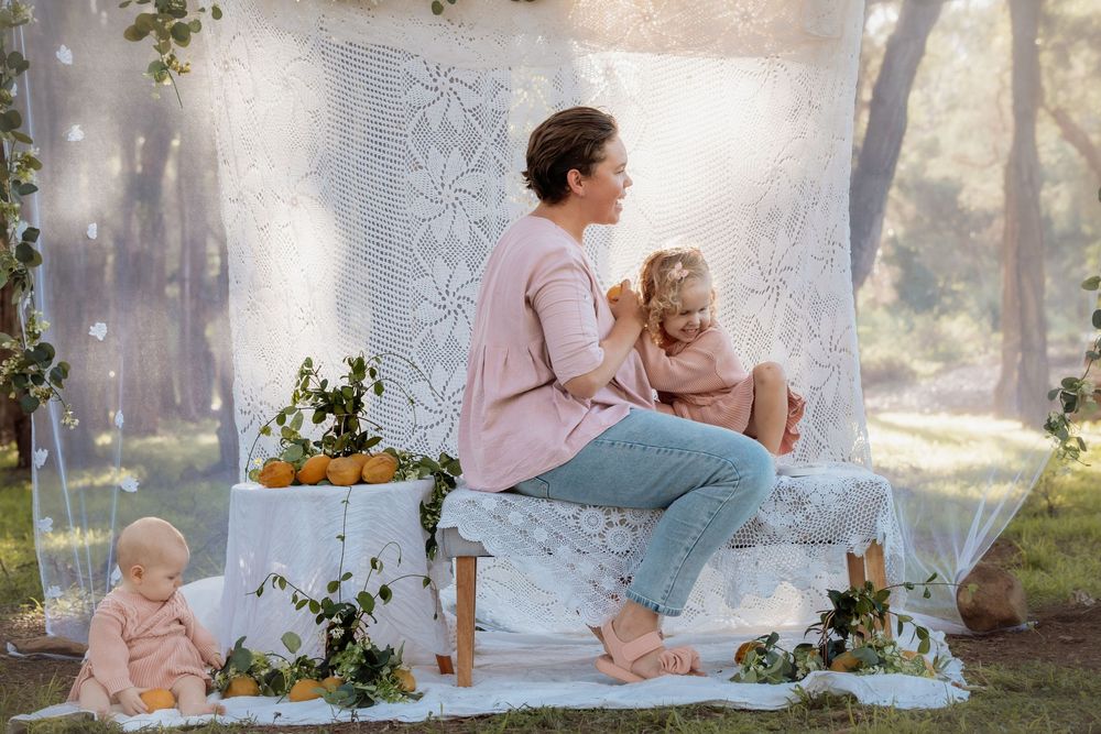 Ethereal outdoor tea party scene with soft pink decor and floral arrangements in a misty garden setting.